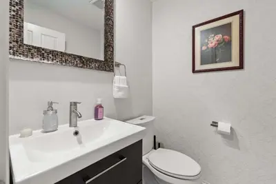a white bathroom with a sink and a toilet at The Gahanna Grand in Columbus