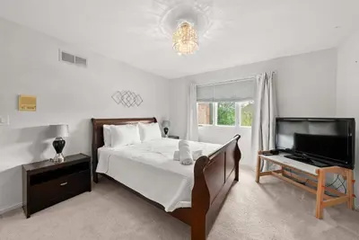 a bedroom with a bed and a flat screen tv at The Gahanna Grand in Columbus