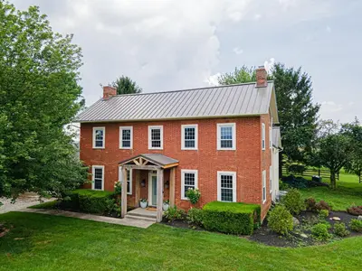 a large red brick house with a yard at Bellawood Farmhouse in Canal Winchester