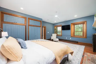 a bedroom with a large bed and blue walls at Bellawood Farmhouse in Canal Winchester