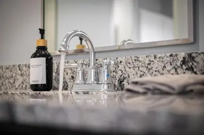 a bottle of wine sitting next to a bathroom sink at King Bed Comfort, Bidet, Fast Wi-Fi, Parking in Cleveland