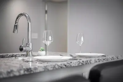 a kitchen counter with two wine glasses and a sink at King Bed Comfort, Bidet, Fast Wi-Fi, Parking in Cleveland