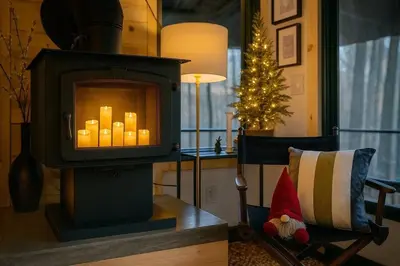 a fireplace in a living room with a christmas tree at Lux Tiny House with Waterfront, Kayaks, Hot Tub, Arcade in Rockbridge