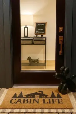 a door with a sign in front of a catlin life rug at Lux Tiny House with Waterfront, Kayaks, Hot Tub, Arcade in Rockbridge