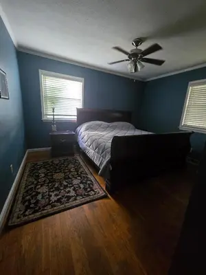 a bedroom with a bed and a ceiling fan at La Casa delle Pesche in Georgetown