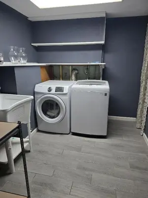 a laundry room with a washing machine and a washer at La Casa delle Pesche in Georgetown