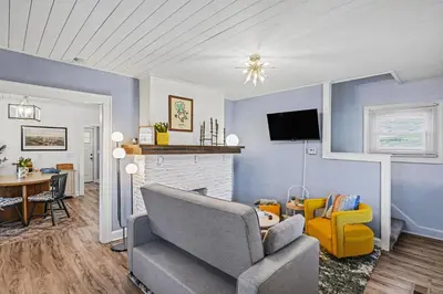 a living room with blue walls and a couch and a table at Cozy Campbell Bungalow in Columbus