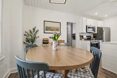 a kitchen and dining room with a wooden table and chairs at Cozy Campbell Bungalow in Columbus