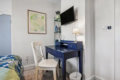 a bedroom with a blue desk with a chair and a bed at Cozy Campbell Bungalow in Columbus