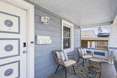 a porch with two chairs and a door at Cozy Campbell Bungalow in Columbus