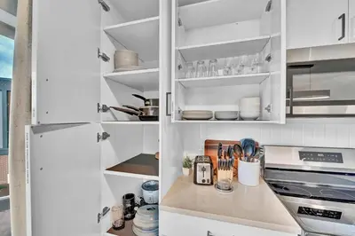 a kitchen with white cabinets with utensils at Stay in Cleveland mins to Cleveland Clinic, Hospitals, Museum, Universities & Downtown in Cleveland
