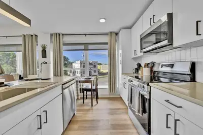 a kitchen with white cabinets and a large window at Stay in Cleveland mins to Cleveland Clinic, Hospitals, Museum, Universities & Downtown in Cleveland