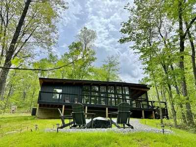 a cabin in the woods with a table and chairs at The Briar House in McArthur