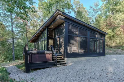 a black tiny house in the woods at The Briar House in McArthur