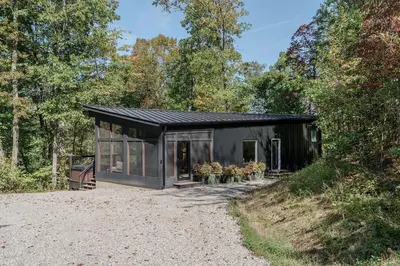a black tiny house in the woods at The Briar House in McArthur