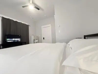 a bedroom with two white beds and a ceiling fan at The Uno Room first floor 10 min d-town 15 airport in Cleveland
