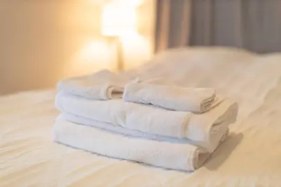 a stack of towels sitting on top of a bed at The Uno Room first floor 10 min d-town 15 airport in Cleveland