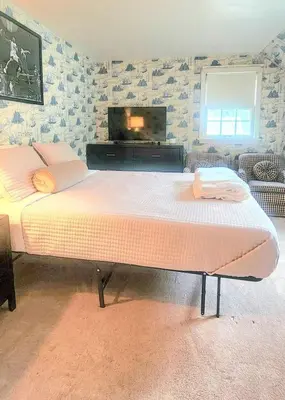 a bedroom with a large bed and a flat screen tv at Your Home Away from Home Sleeps 12 Fully Equipped in Youngstown