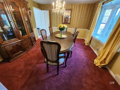 a dining room with a table and chairs on a purple carpet at Your Home Away from Home Sleeps 12 Fully Equipped in Youngstown