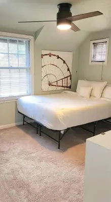 a large bed in a room with a ceiling fan at Your Home Away from Home Sleeps 12 Fully Equipped in Youngstown