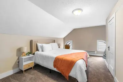 a bedroom with a large bed with an orange blanket at Spacious Home Near Hospitals with Office & Game Room in Cleveland Heights