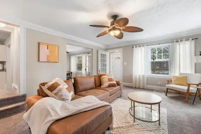 a living room with a couch and a ceiling fan at Spacious Home Near Hospitals with Office & Game Room in Cleveland Heights