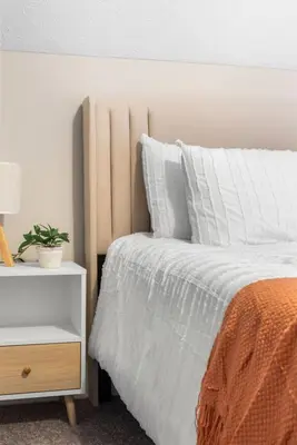 a bedroom with a white bed and a night stand at Spacious Home Near Hospitals with Office & Game Room in Cleveland Heights