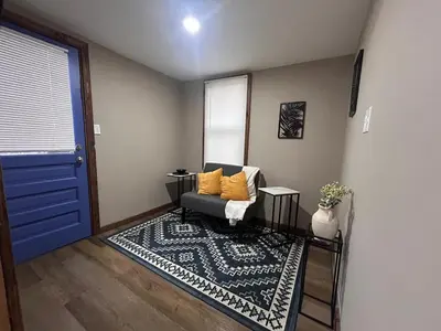 a living room with a couch and a blue door at A gem in the heart of Cleveland Unit 3 in Cleveland