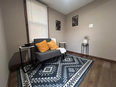a living room with a chair and a rug at A gem in the heart of Cleveland Unit 3 in Cleveland