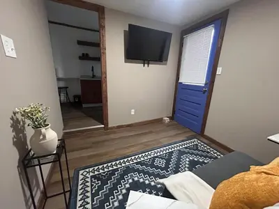a living room with a blue door and a television at A gem in the heart of Cleveland Unit 3 in Cleveland