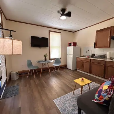a living room with a table and a kitchen at Urban OASIS Inspired by the 80s Unit 1 in Cleveland