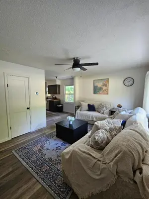 a living room with a couch and a ceiling fan at Cozy 3BR Cottage Near Headlands in Mentor