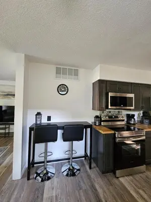 a kitchen with a counter and two bar stools at Cozy 3BR Cottage Near Headlands in Mentor