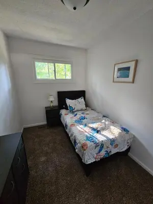 a small bedroom with a bed and a window at Cozy 3BR Cottage Near Headlands in Mentor