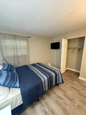 a bedroom with a bed and a flat screen tv at Comfortable and Calm Stay in Columbus in Columbus