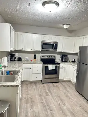 a kitchen with white cabinets and stainless steel appliances at Comfortable and Calm Stay in Columbus in Columbus