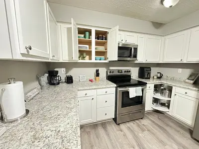 a kitchen with white cabinets and a stove top oven at Comfortable and Calm Stay in Columbus in Columbus