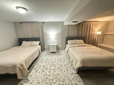 a bedroom with two beds and a table with a lamp at Comfortable and Calm Stay in Columbus in Columbus