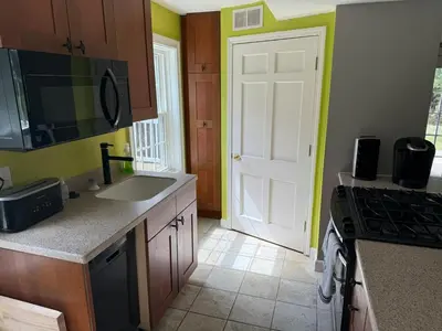 a kitchen with a sink and a white door at Old Orchard Kirtland, Ohio