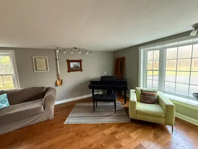 a living room with a couch and a piano at Old Orchard Kirtland, Ohio