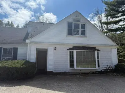 a white house with a window and a garage at Old Orchard Kirtland, Ohio