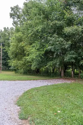 a gravel road in a park with a tree at Ravenwood in Killbuck