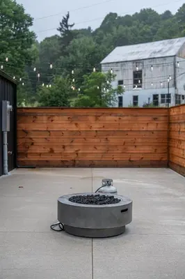 a fountain on a patio with a wooden fence at Ravenwood in Killbuck
