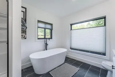a white bathroom with a tub and a window at Ravenwood in Killbuck