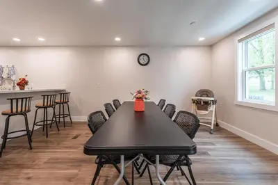 a conference room with a table and chairs and a clock at The Gathering Haus in Dalton