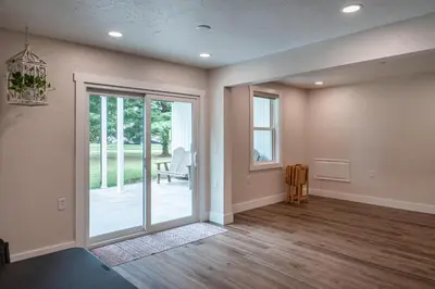an empty living room with a sliding glass door at The Gathering Haus in Dalton