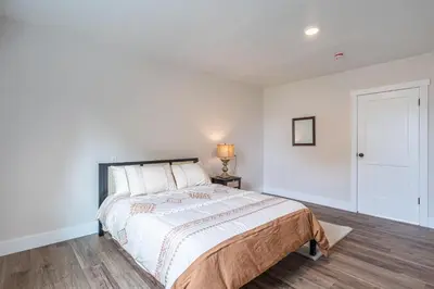 a white bedroom with a bed and a lamp at The Gathering Haus in Dalton