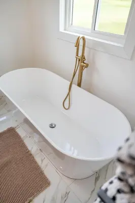 a bathroom with a white toilet with a gold faucet at Swancrest in Killbuck