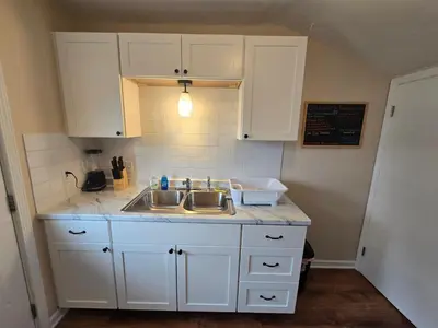 a kitchen with white cabinets and a sink at Townhouse at 99 in Boardman