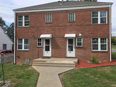 a red brick house with white doors and a porch at Townhouse at 99 in Boardman